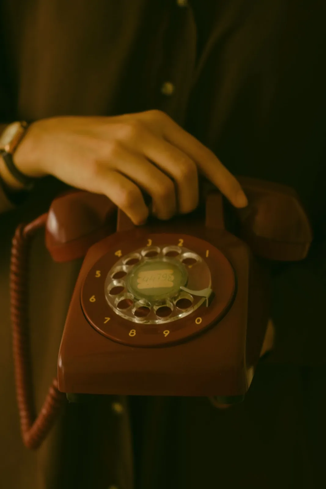 Hands using a rotary telephone, illustrating the familiar pick-up and speak interaction